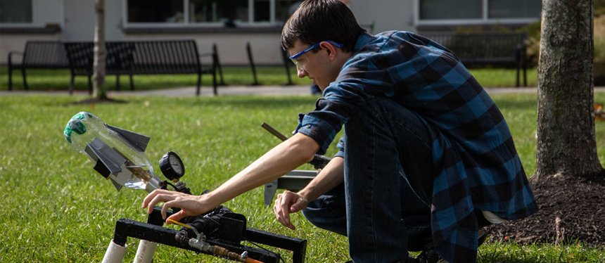 student working outside on engineering rocket