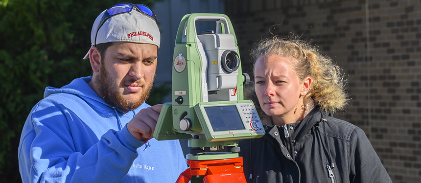 students using survey equipment