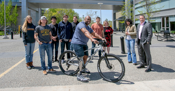 Rowan engineering students Carley Tool, Landyn Bacanskas, Andronikos Nouragas, Ben Afflitto, Anthony Boyko and Kenyon Burgess present an adapted bike to veteran Hilbert Caesar, along with Dr. Jody Kakacek, Dr. Berivan Cecen and Dr. Mark Byrne.