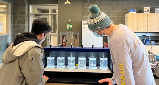 two students viewing water experiment in a lab