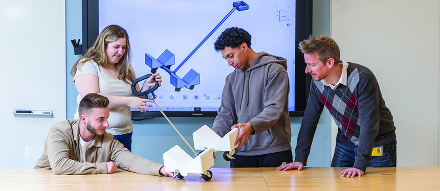 Joshua Perry, biomedical engineering alumnus and MBA student; Alexa Warren, undergraduate student; and Marvin Aquilera Moreno, undergraduate student, are examining the pulling mechanism prototype.