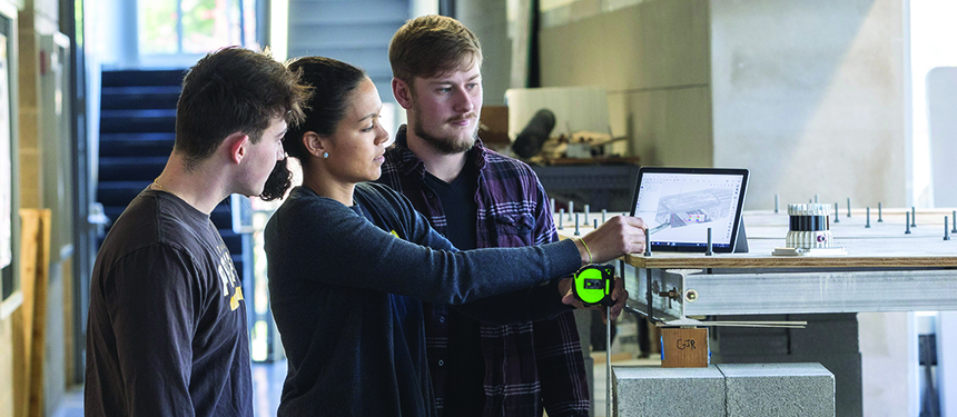 Michael Waldron, civil engineering undergraduate student;   Adriana Trias Blanco, Ph.D.,  assistant professor; and   John Vrabel, Ph.D. candidate,   are viewing the point   cloud of a bridge.