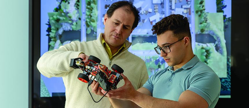 Robi Polikar, Ph.D., department head of electrical and computer engineering, and Chaz Allegra, electrical and computer engineering  MS student, inspecting the robotic car.