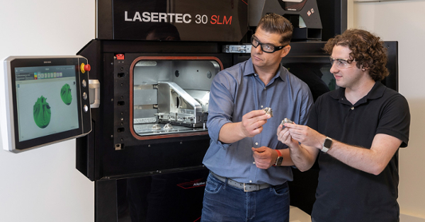 Dr. Antonios Kontsos and mechanical engineering senior Sam Menaker work with the lab’s key piece of equipment, a 3D metal printer connected to a supercomputer.