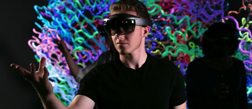 student with virtual reality glasses on with colorful background