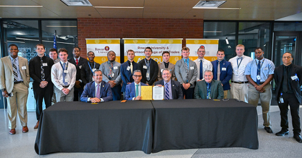 Williamson College of the Trades and Rowan University students and leaders pose for a photo after formalizing a new pathway toward a bachelor's degree in construction management